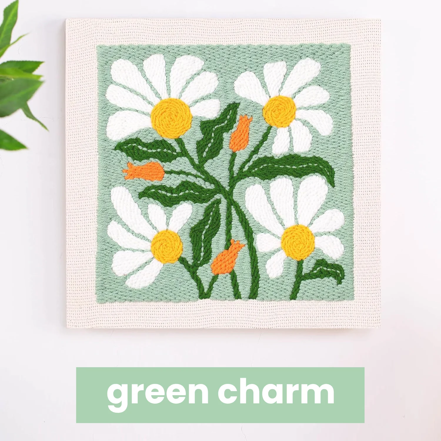Embroidered daisies with green leaves on a canvas, labeled 'green charm.'