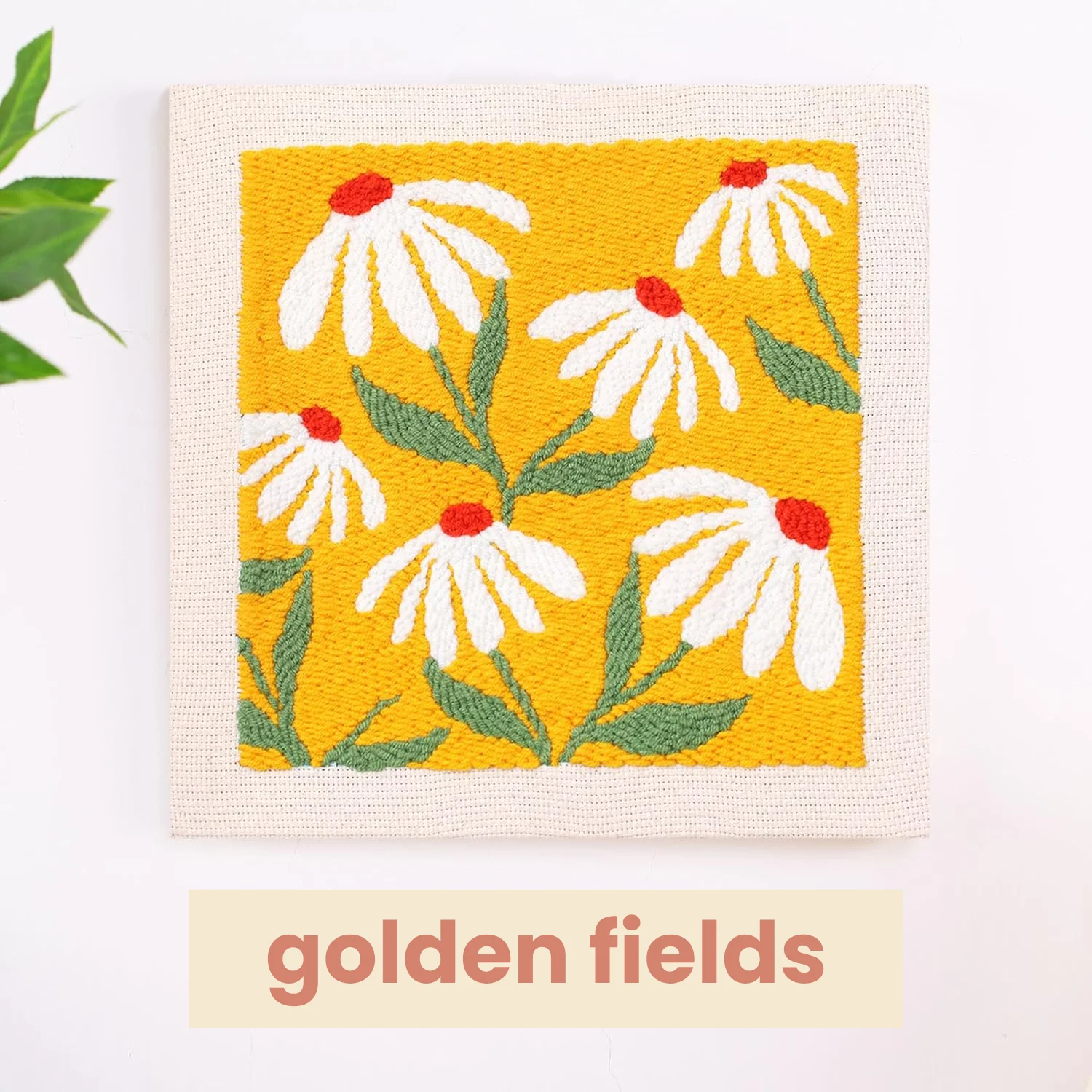Embroidery of white flowers with green leaves on a yellow background.