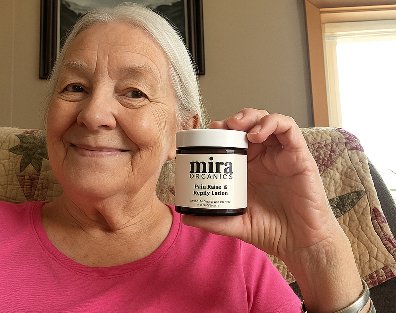 A smiling older woman in a pink shirt holds up a jar of Mira Organics lotion.