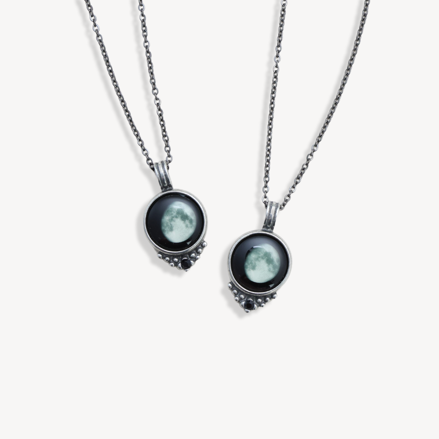 Two necklaces with moon pendants on silver chains.