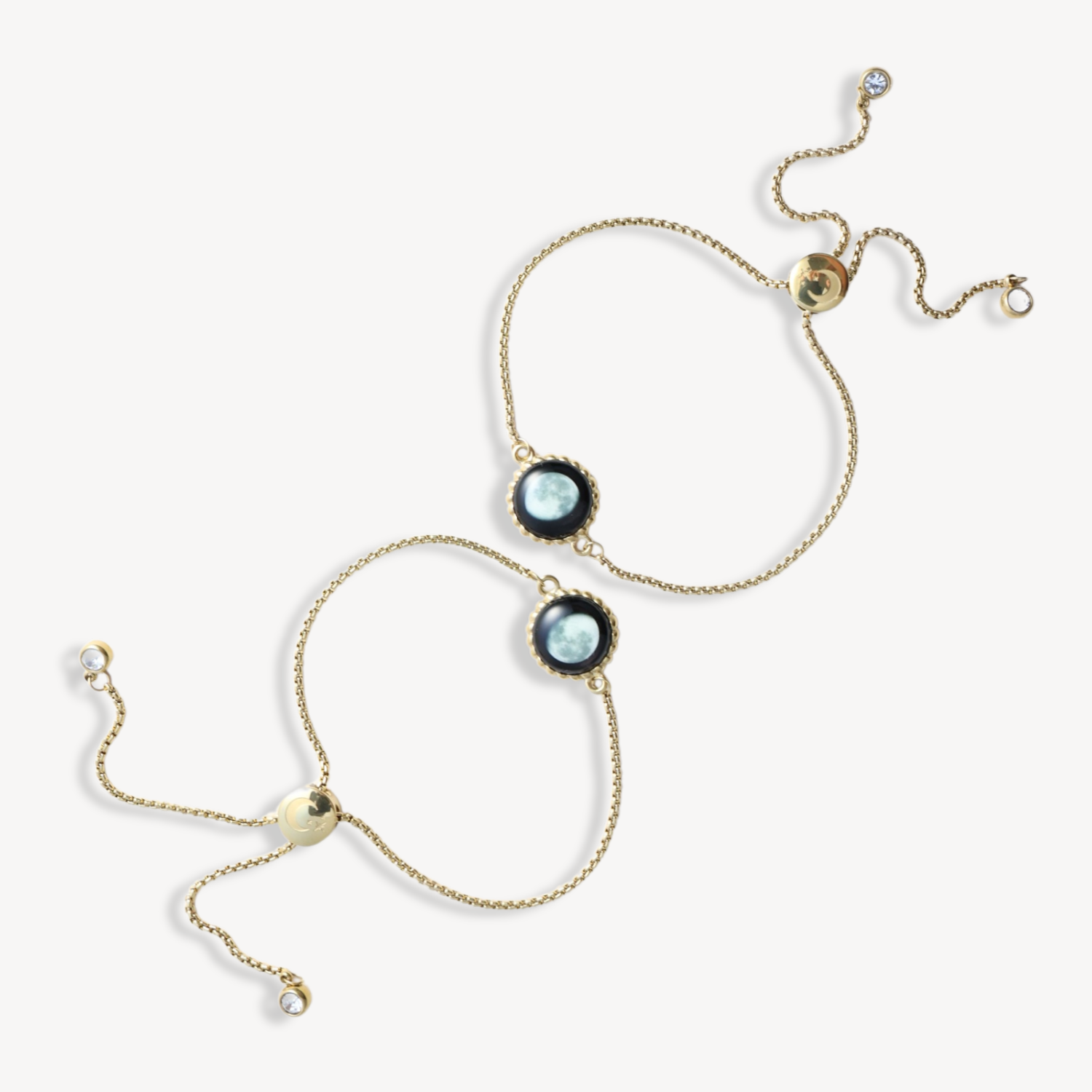 Two gold chain bracelets with blue gemstone centers on a white background.