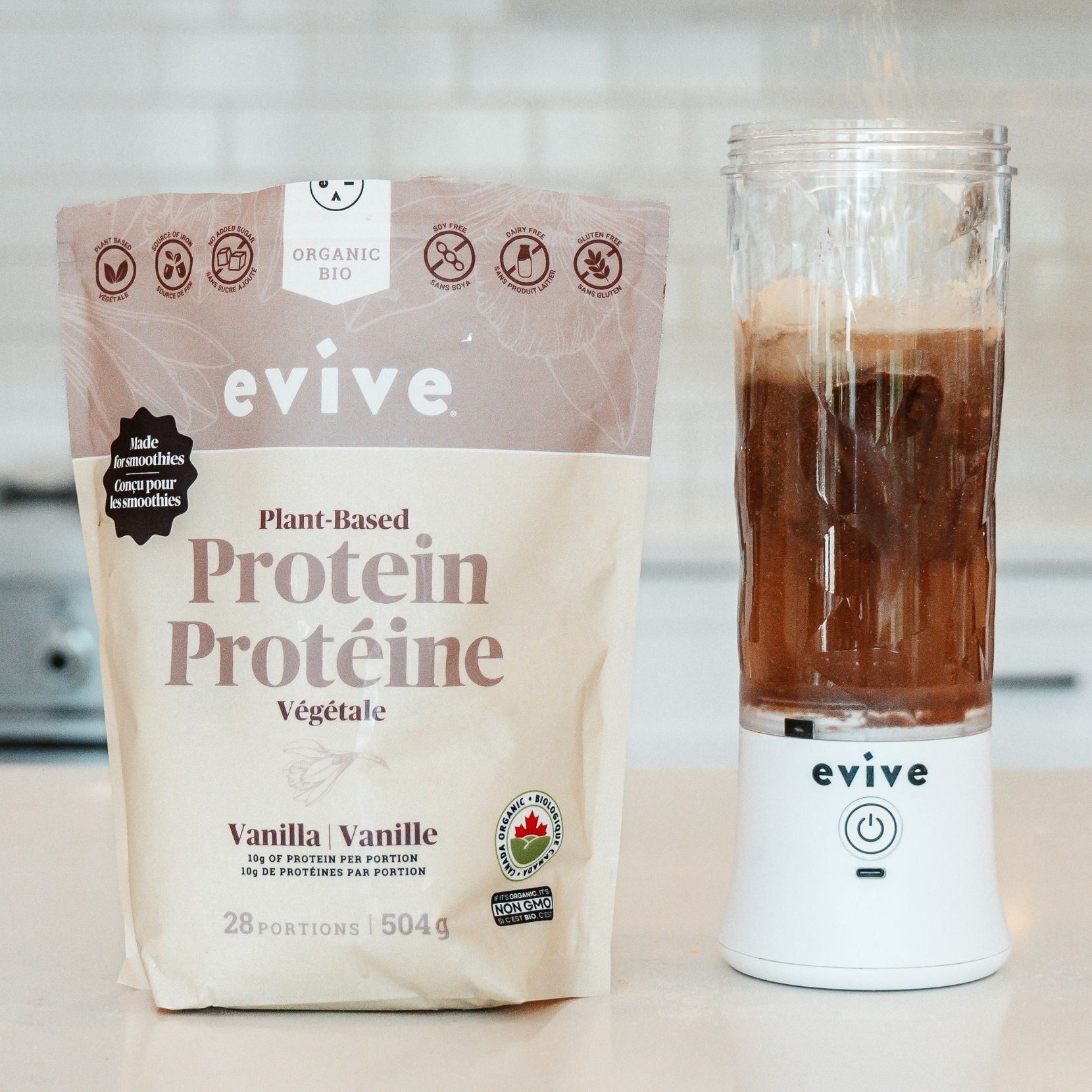 Evive plant-based protein powder beside a blender with a brown liquid.