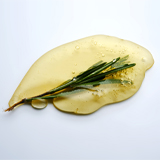 A sprig of rosemary on a smear of golden liquid.