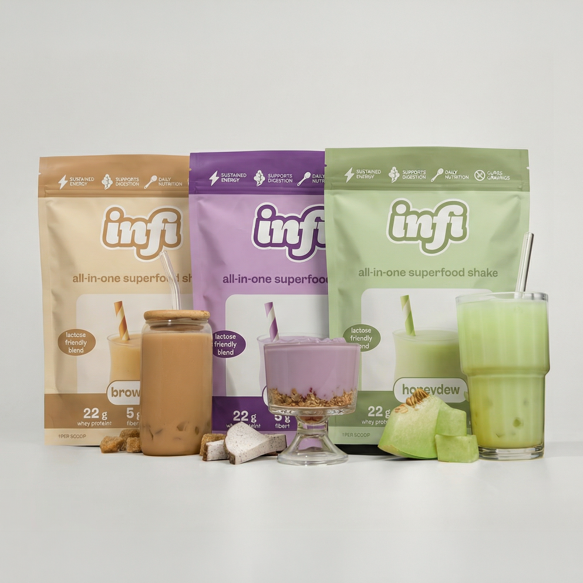 Three pouches of Infi superfood shake mixes in different flavors, each with a prepared drink in front.