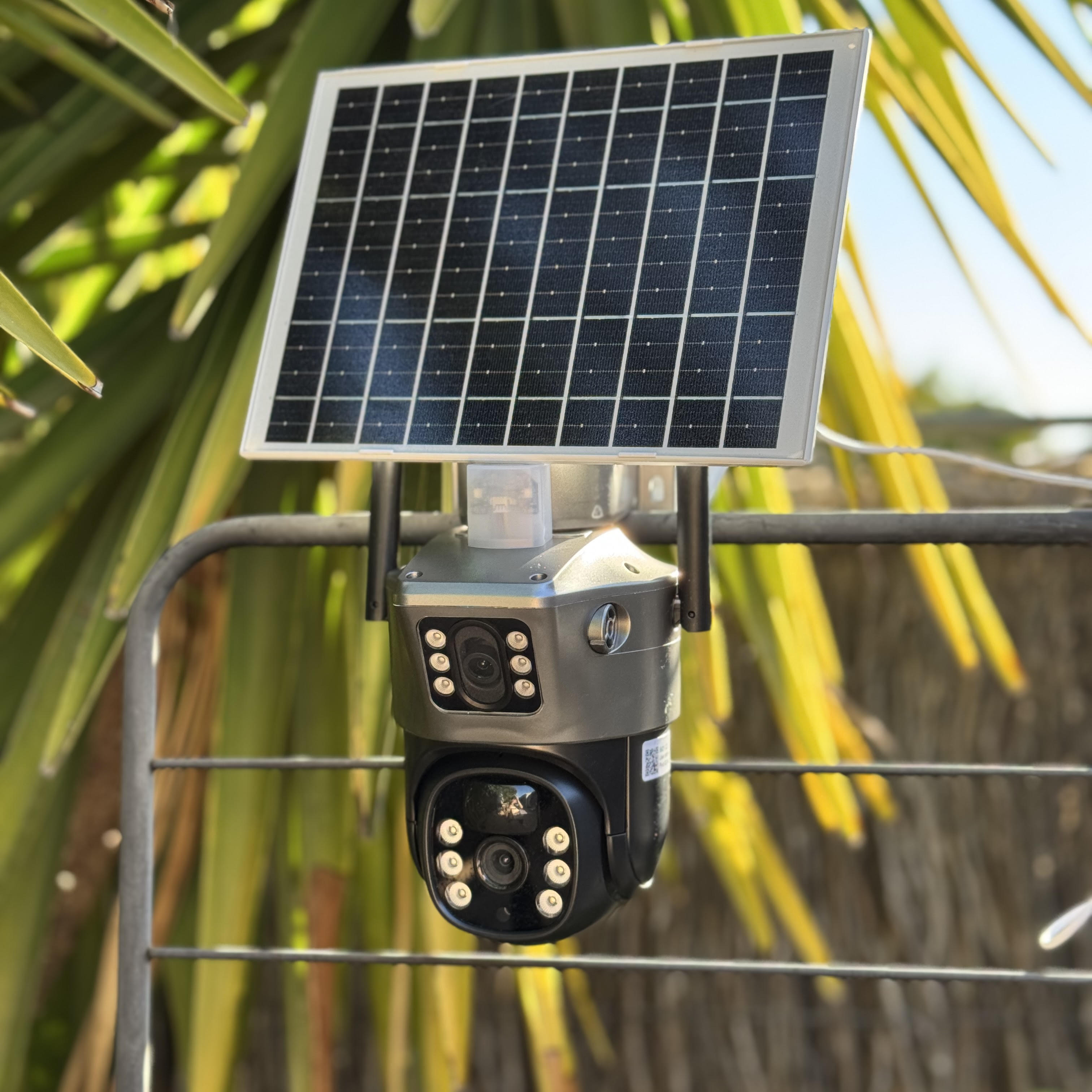 Solar-powered security camera mounted outdoors with foliage in the background.