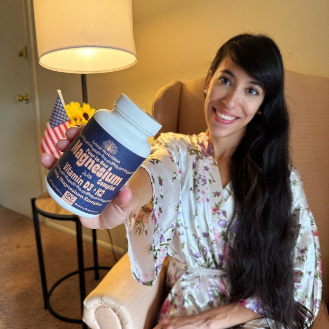 A smiling woman in a floral robe holds up a bottle of Local Nutrition Magnesium Complex supplement.