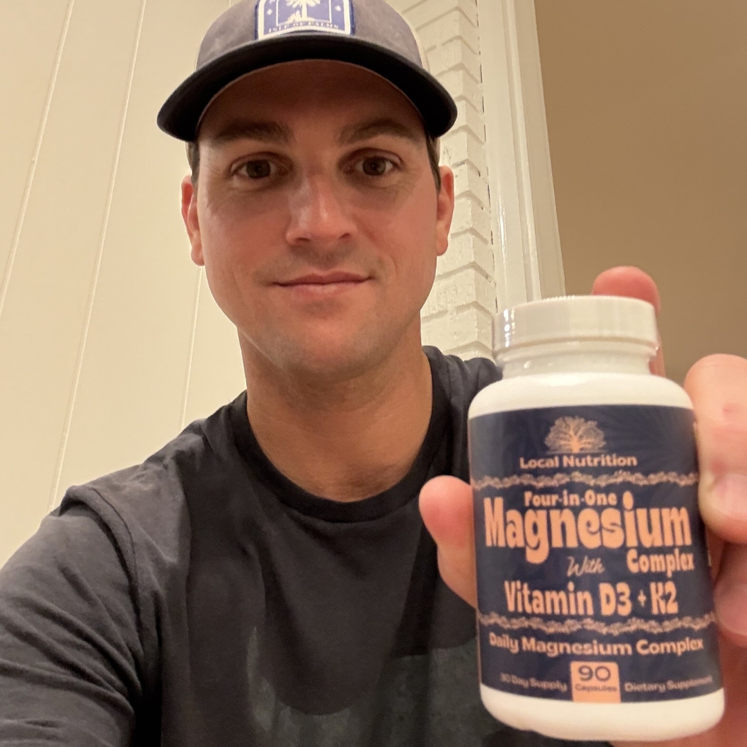 Person holding a bottle of magnesium supplement.