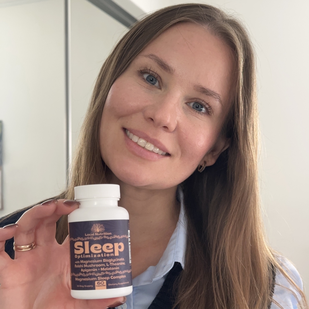 Person smiling and holding a bottle of sleep supplements.
