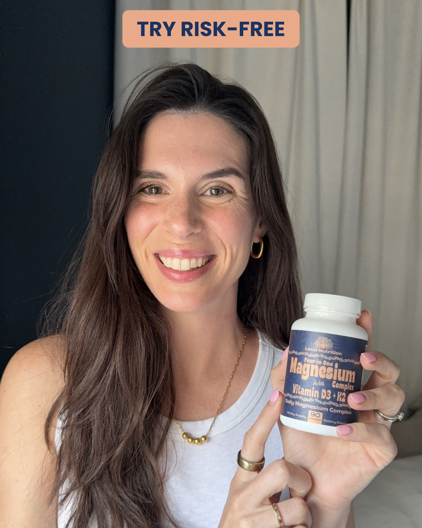 A smiling woman with brown hair holds up a bottle of Local Nutrition Magnesium Complex supplements.