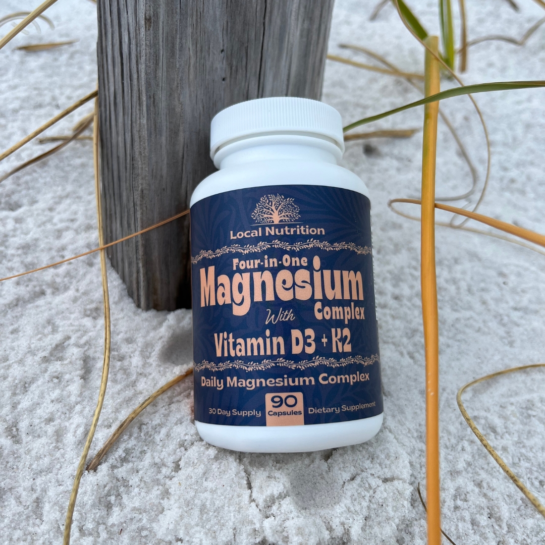 Vitamin bottle on sandy ground with wooden post and grass.