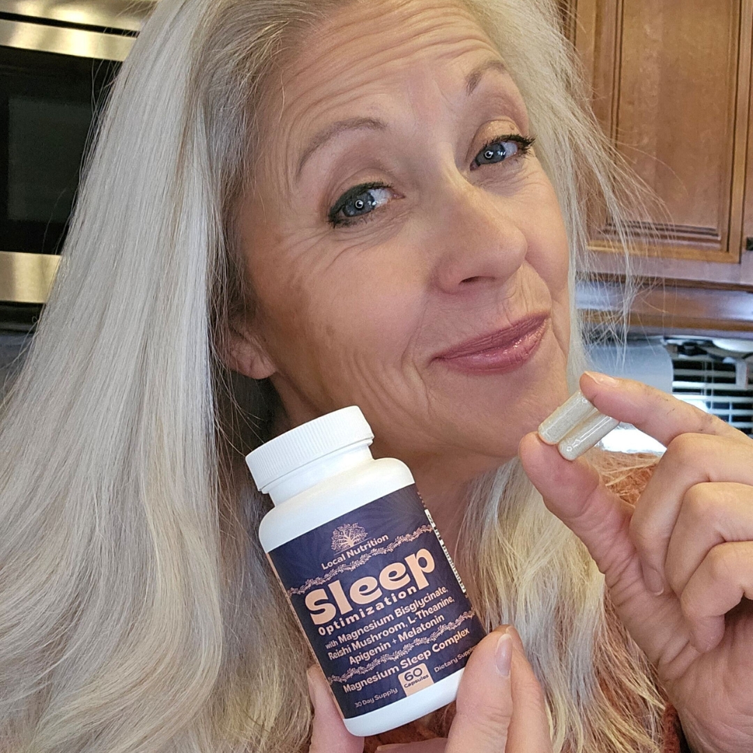 Person holding a bottle labeled 'Sleep' and two capsules.