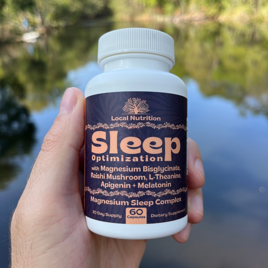 Person holding a bottle labeled Sleep Optimization by a lake.