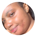A close-up, circular photo of a smiling Black woman with her hair pulled back, looking at the camera.