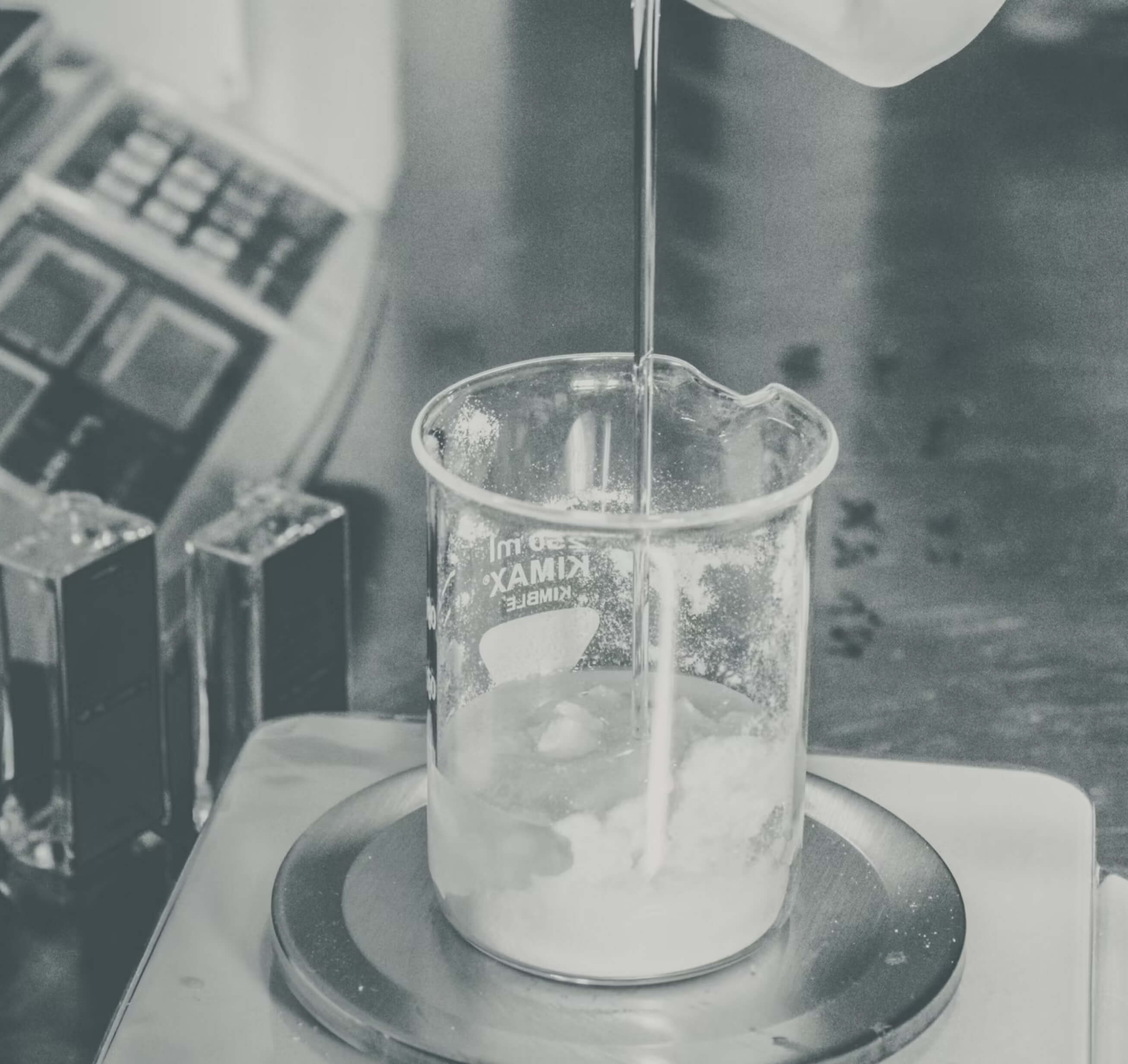 Liquid being poured into a beaker on a digital scale.