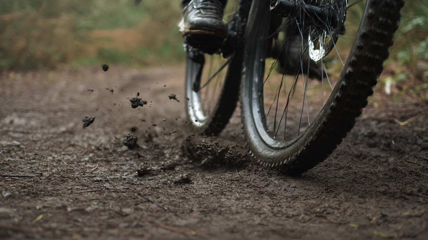 Close-up of a mountain bike tire splashing mud on a trail.