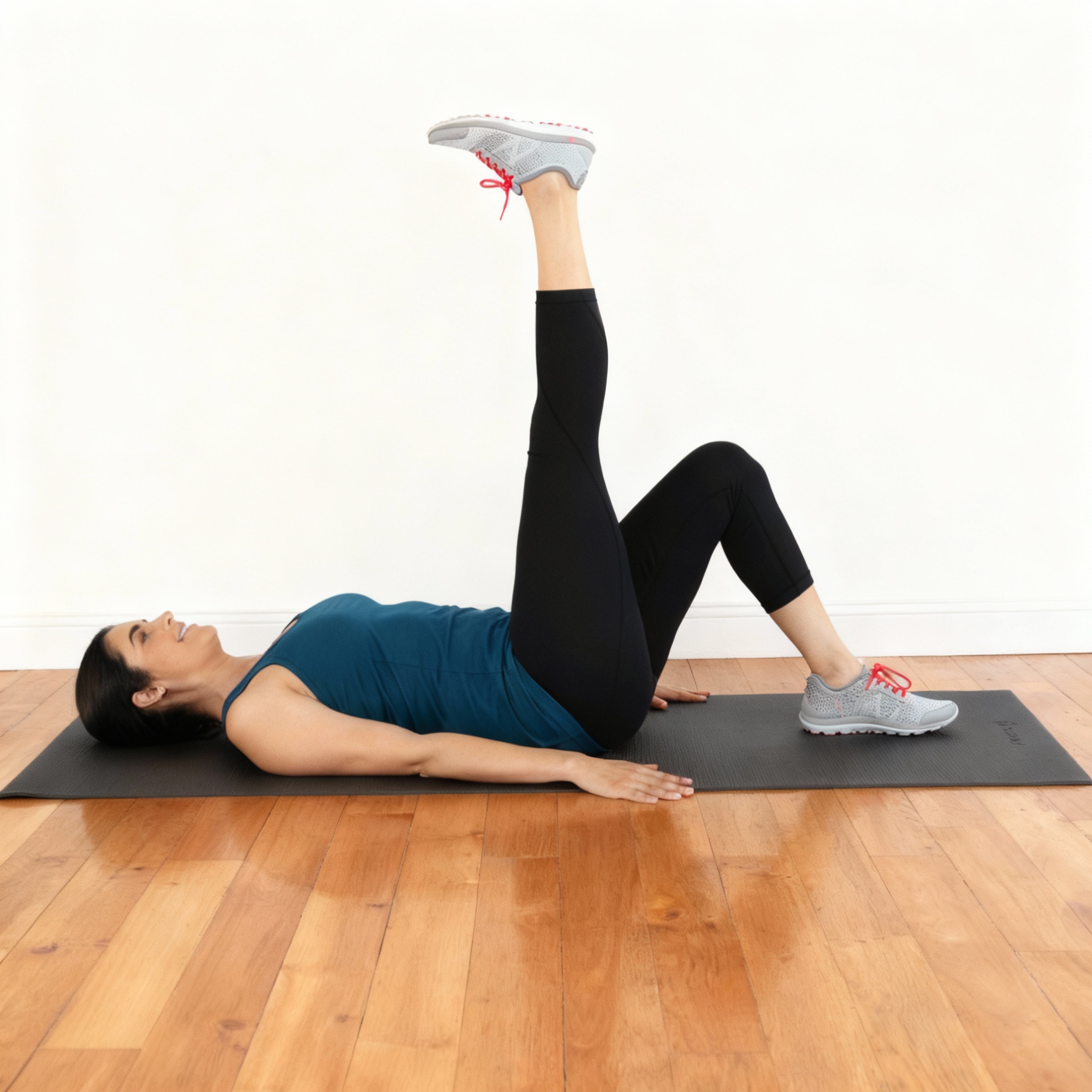 Person lying on a mat, one leg raised vertically.