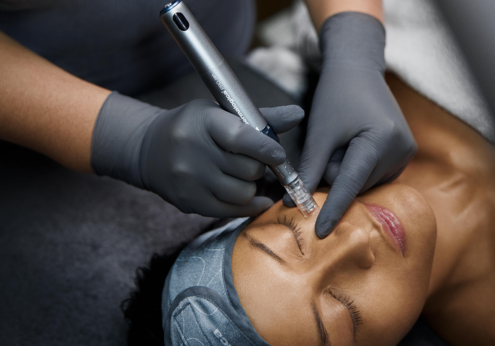Person receiving a facial treatment with a handheld device, wearing a headband.