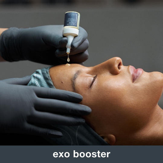 Person receiving a skincare treatment with a dropper on their forehead.