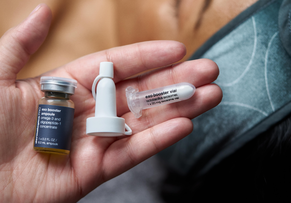 Hand holding skincare ampoule, vial, and applicator.