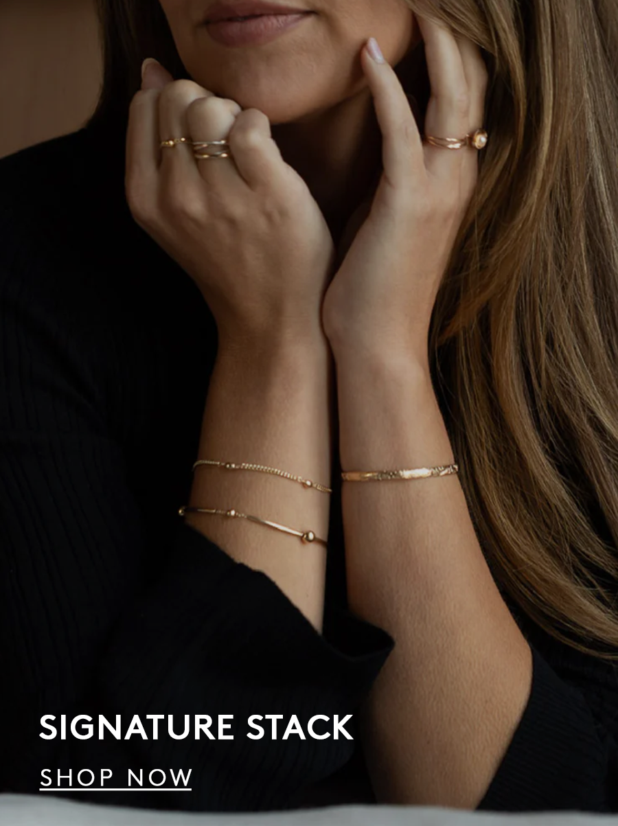 Woman wearing a bracelet stack with hands touching her face. text reads signature stack. shop now button.