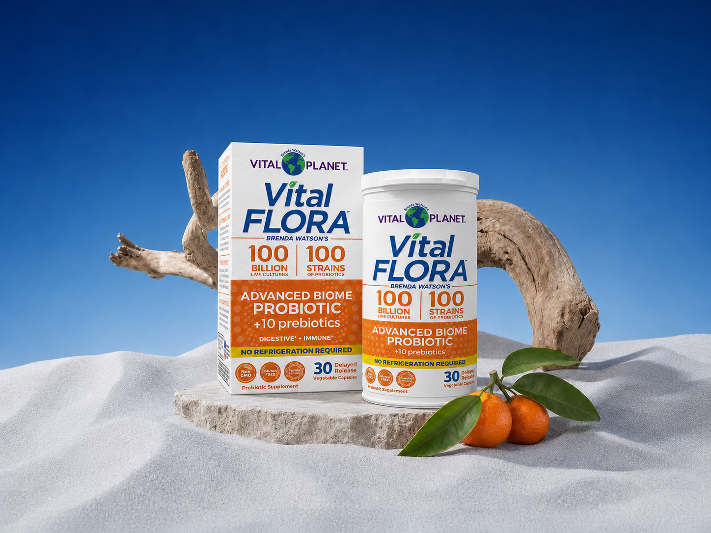 A bottle and box of Vital Flora probiotic supplements displayed on a sandy beach scene with driftwood.