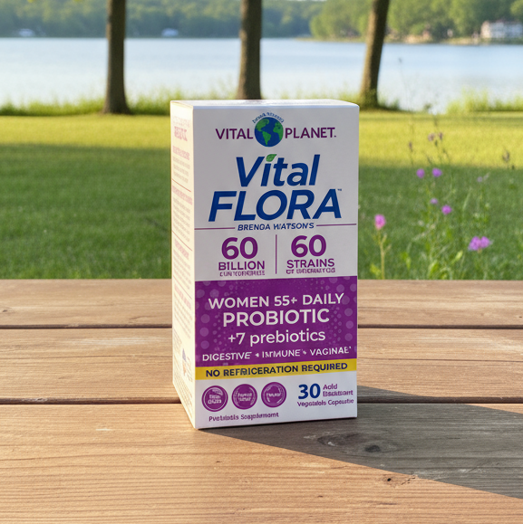 Vital Flora probiotic box on wooden table with lake and trees in background.