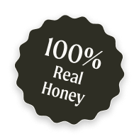 A dark, scalloped-edge seal with white text that reads '100% Real Honey'.
