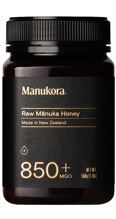 Black jar labeled 'Manukora Raw Mānuka Honey' with 850+ MGO, 500g.