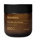 Brown jar labeled 'Manukora Raw Mānuka Honey 850+' with a black lid.