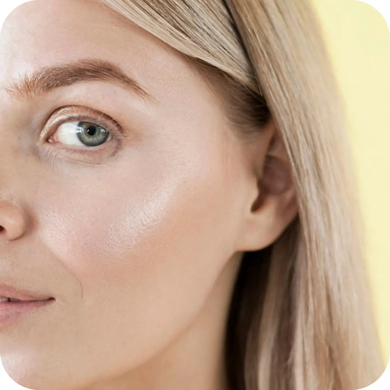 Close-up of a person's face with light hair against a yellow background.