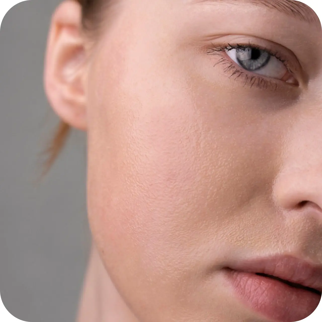 Close-up of a person's right eye and cheek with natural skin texture.