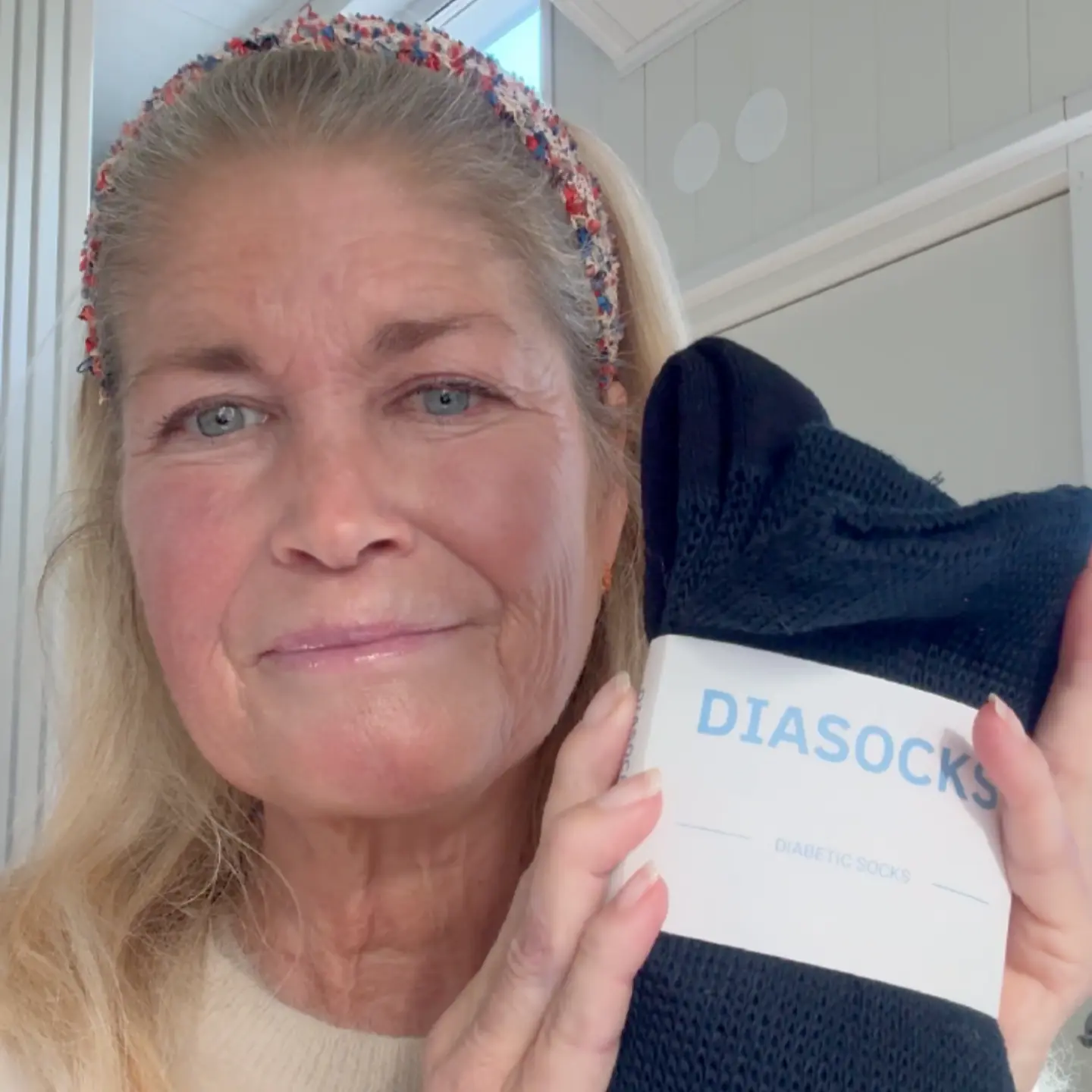 Person holding a package of black diabetic socks labeled 'DIASOCKS.'