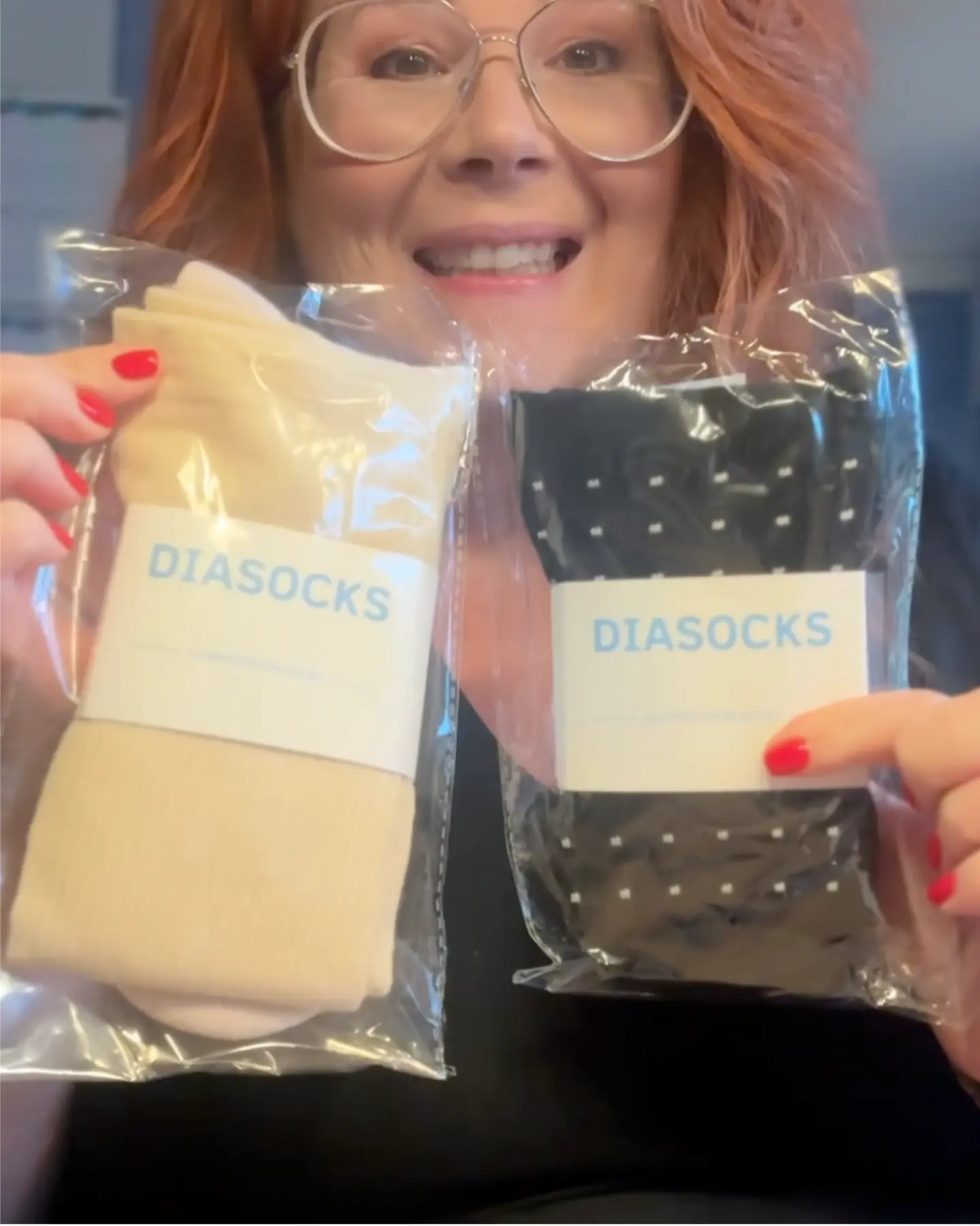 Person holding packaged socks labeled 'DIASOCKS' in beige and black colors.