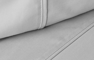A close-up shot of folded light gray fabric with visible seams and stitching.