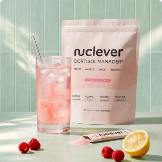 A pouch of Nuclev Cortisol Manager next to a pink drink, raspberries, and a lemon.