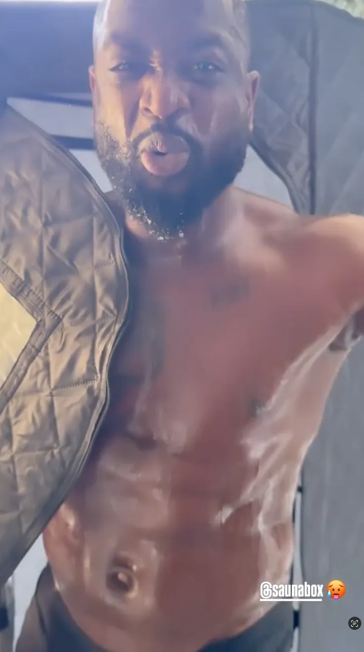 Man emerging from a sauna tent, looking intense and sweaty.