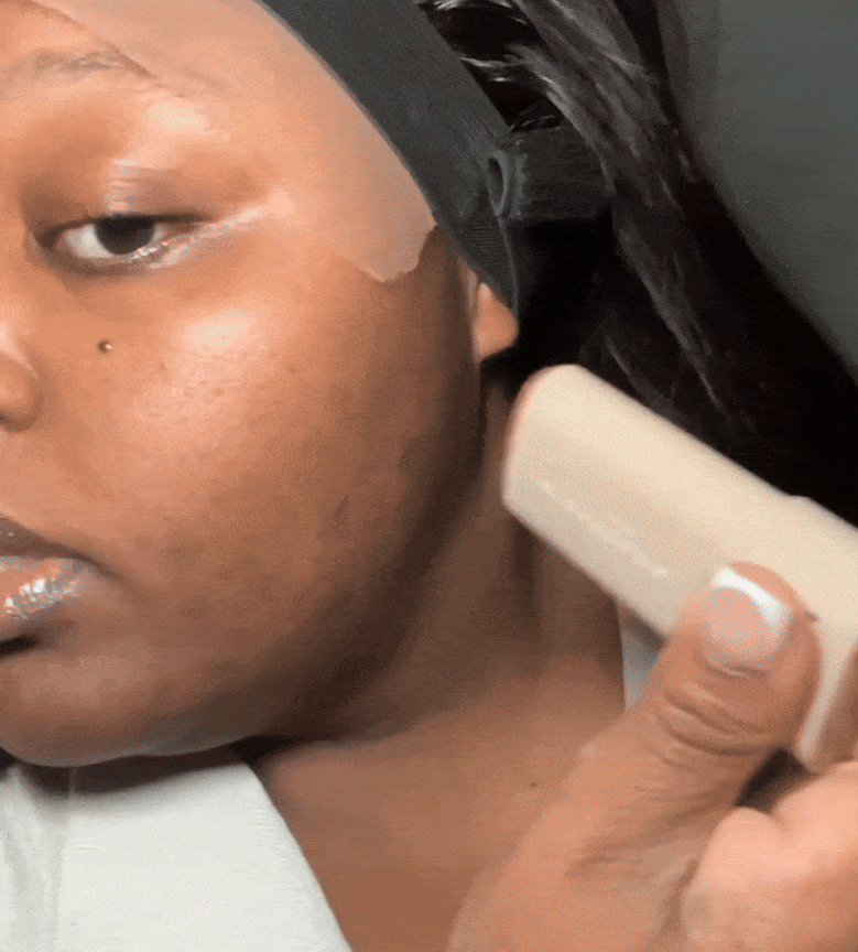 Person applying foundation with a brush on their cheek.