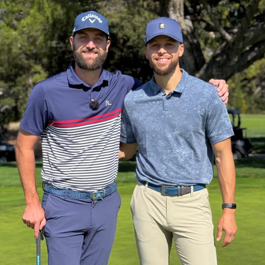 Two men in golf attire posing on a golf course.