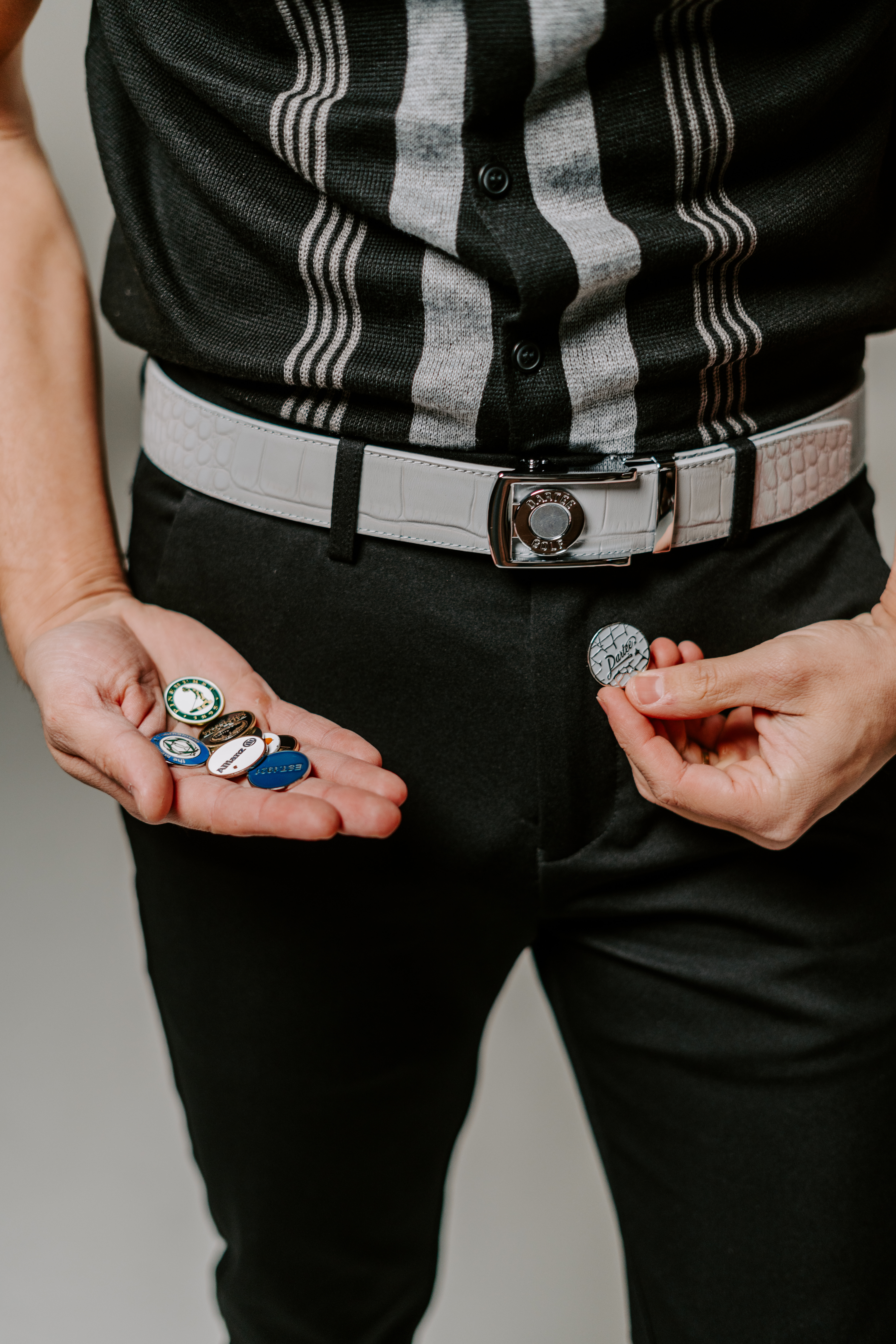 Person holding small round pins in their hands.