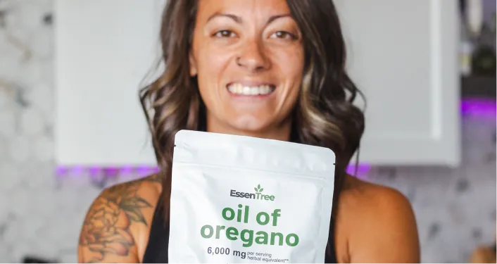 Person holding a package labeled 'oil of oregano.'