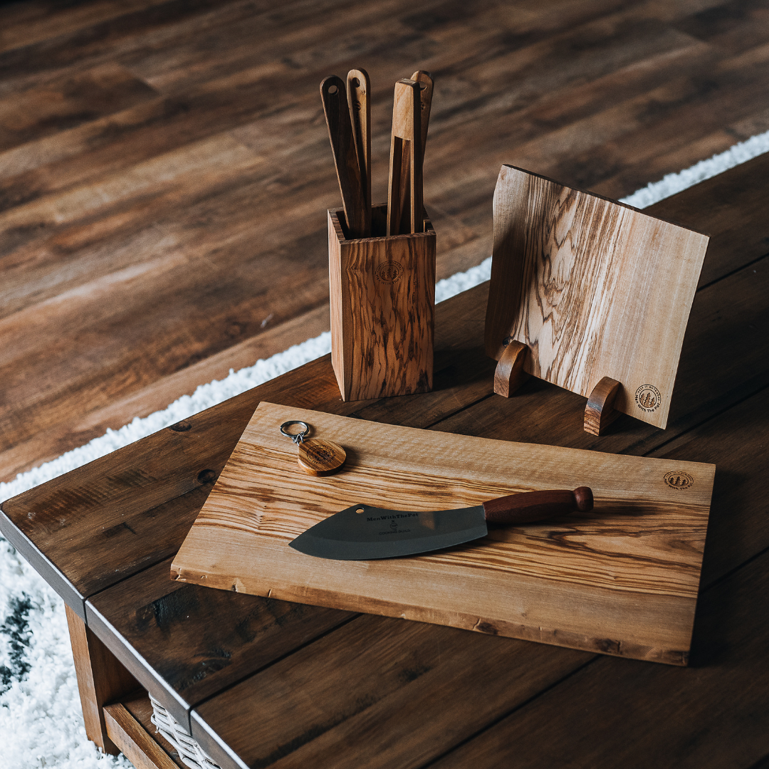 Wooden kitchen utensils and cutting board on a wooden table.