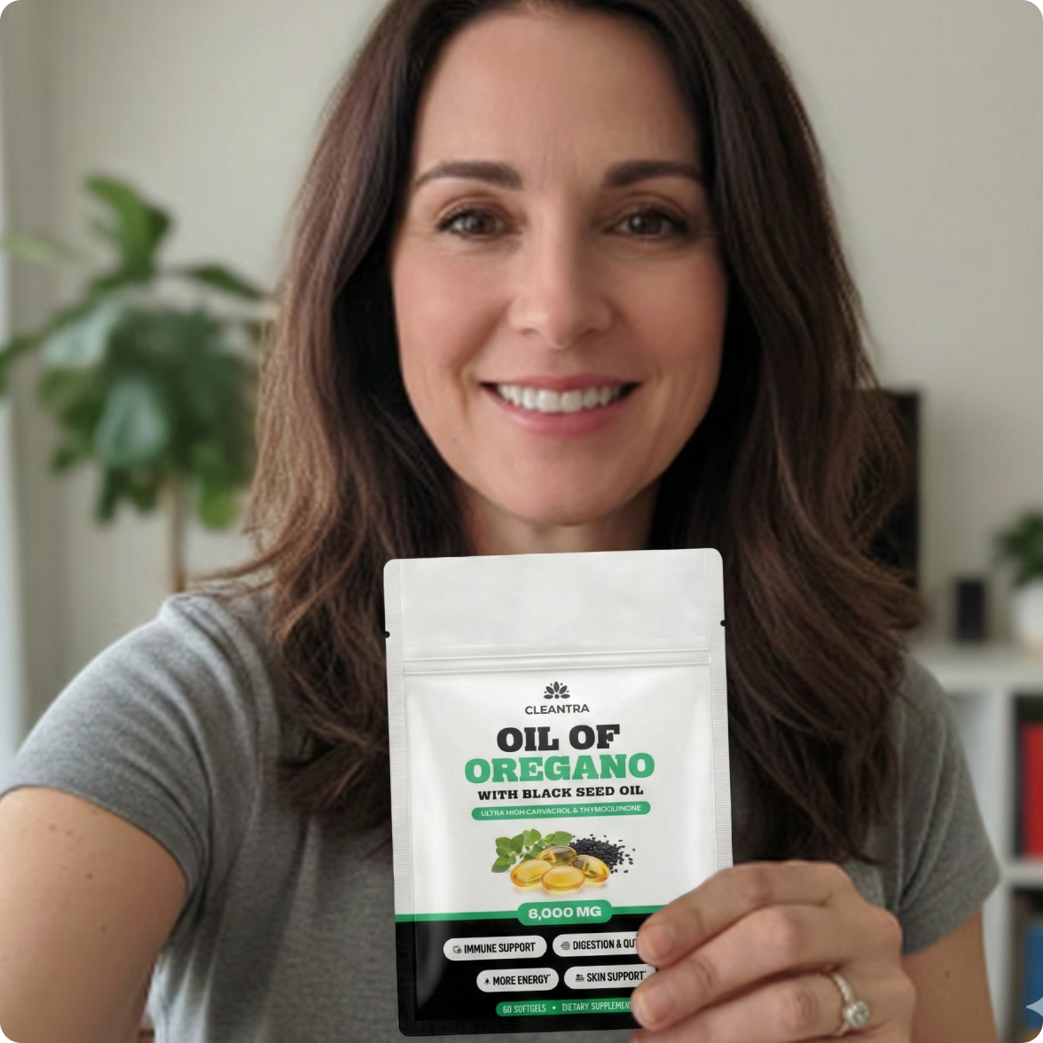 A smiling woman holds up a pouch of Cleantra Oil of Oregano with Black Seed Oil.