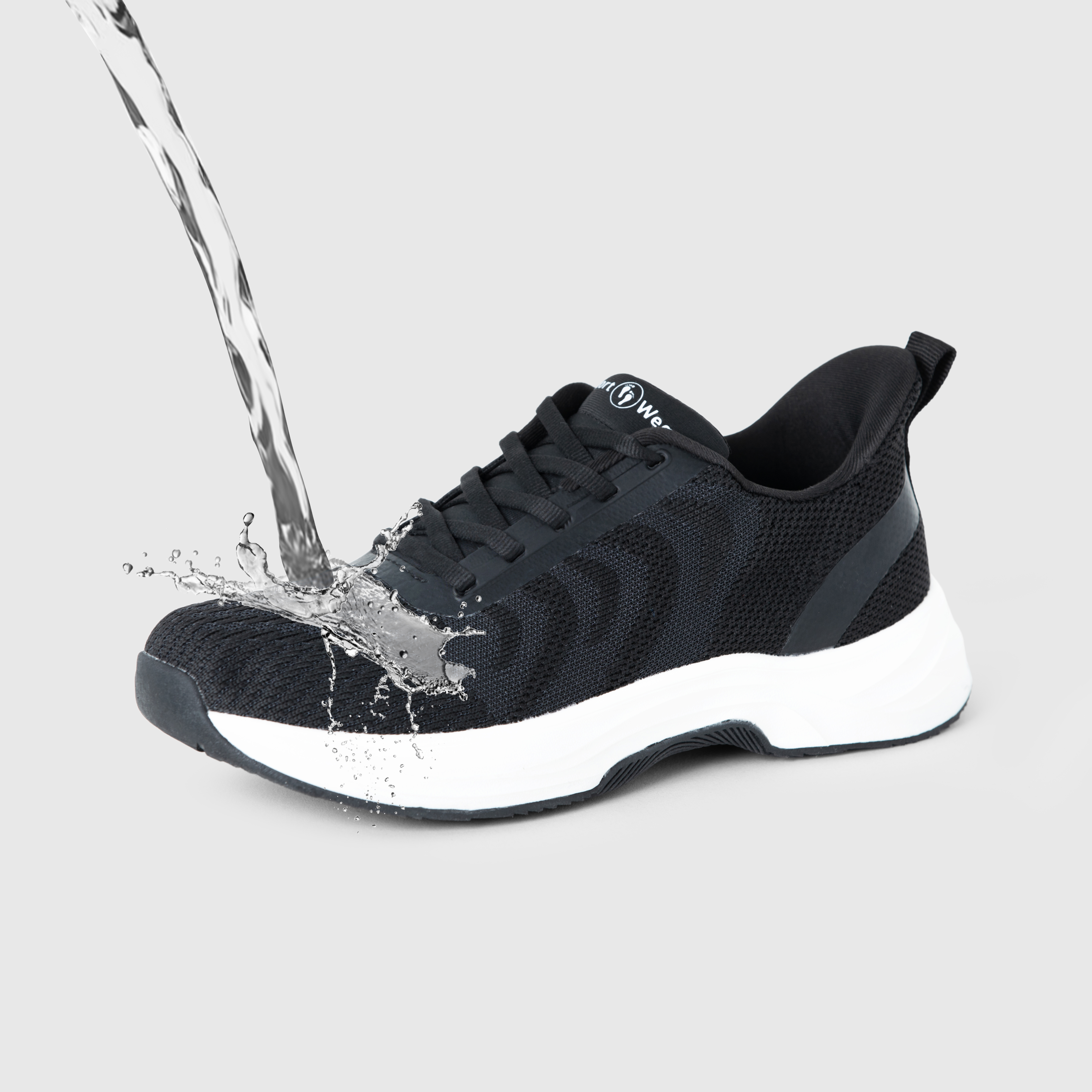 Black sneaker with water splashing on it, demonstrating water resistance.
