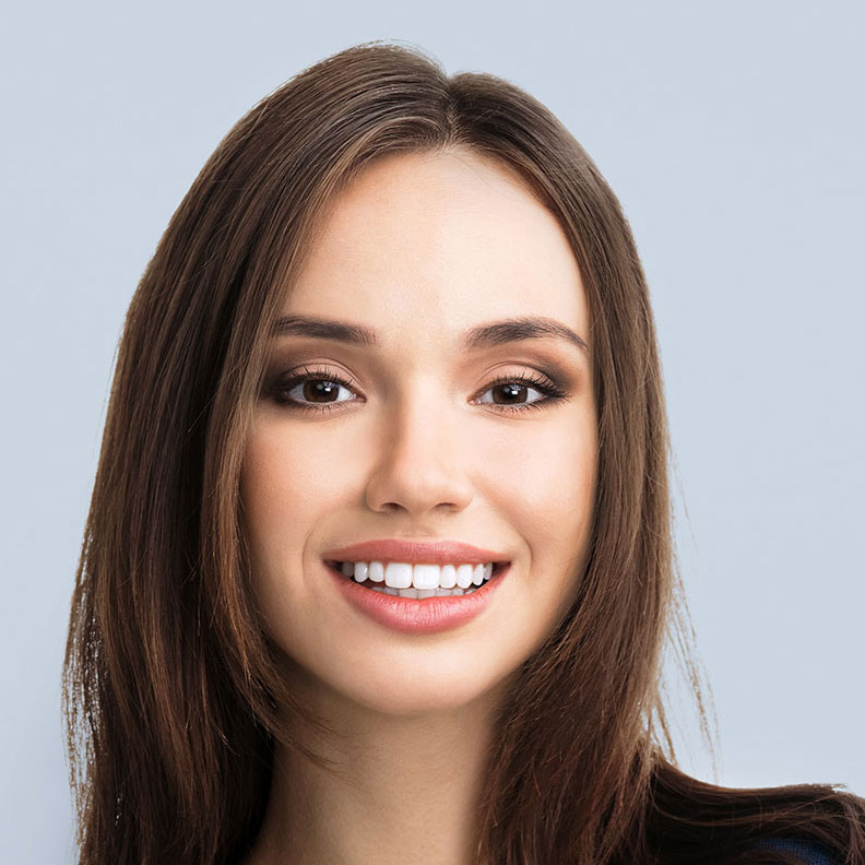 Smiling woman with brown hair against a light gray background.