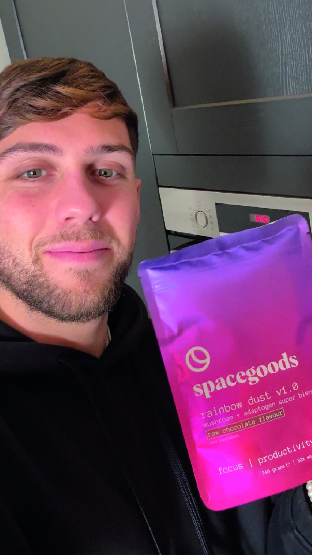 Person holding a purple bag labeled 'spacegoods rainbow dust v1.0' in a kitchen.