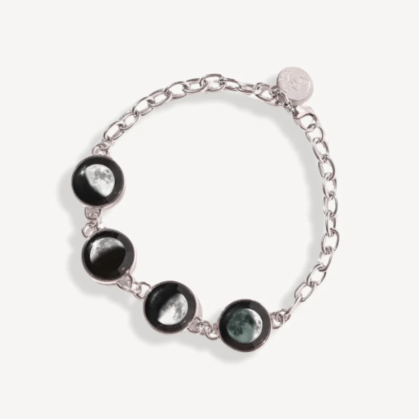 Silver bracelet with moon phase charms on a white background.
