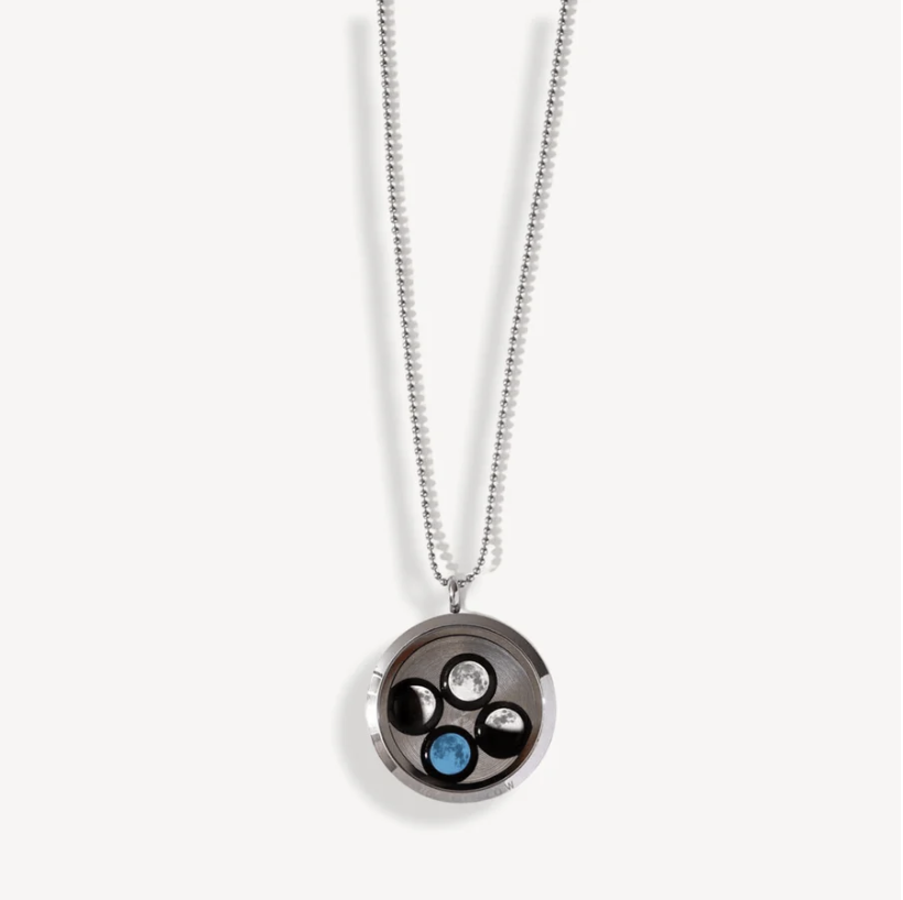 Silver necklace with a round pendant featuring moon phase designs.