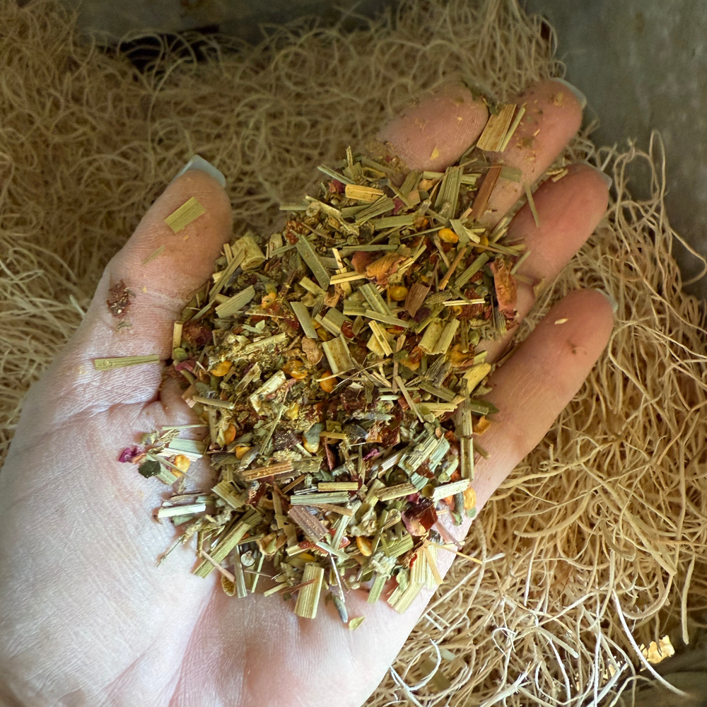 A hand holding a mixture of dried herbs and leaves.
