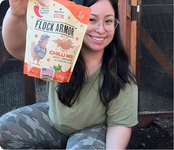 A smiling woman with glasses holds up a bag of Flock Armor Chilli Mix with Oregano.