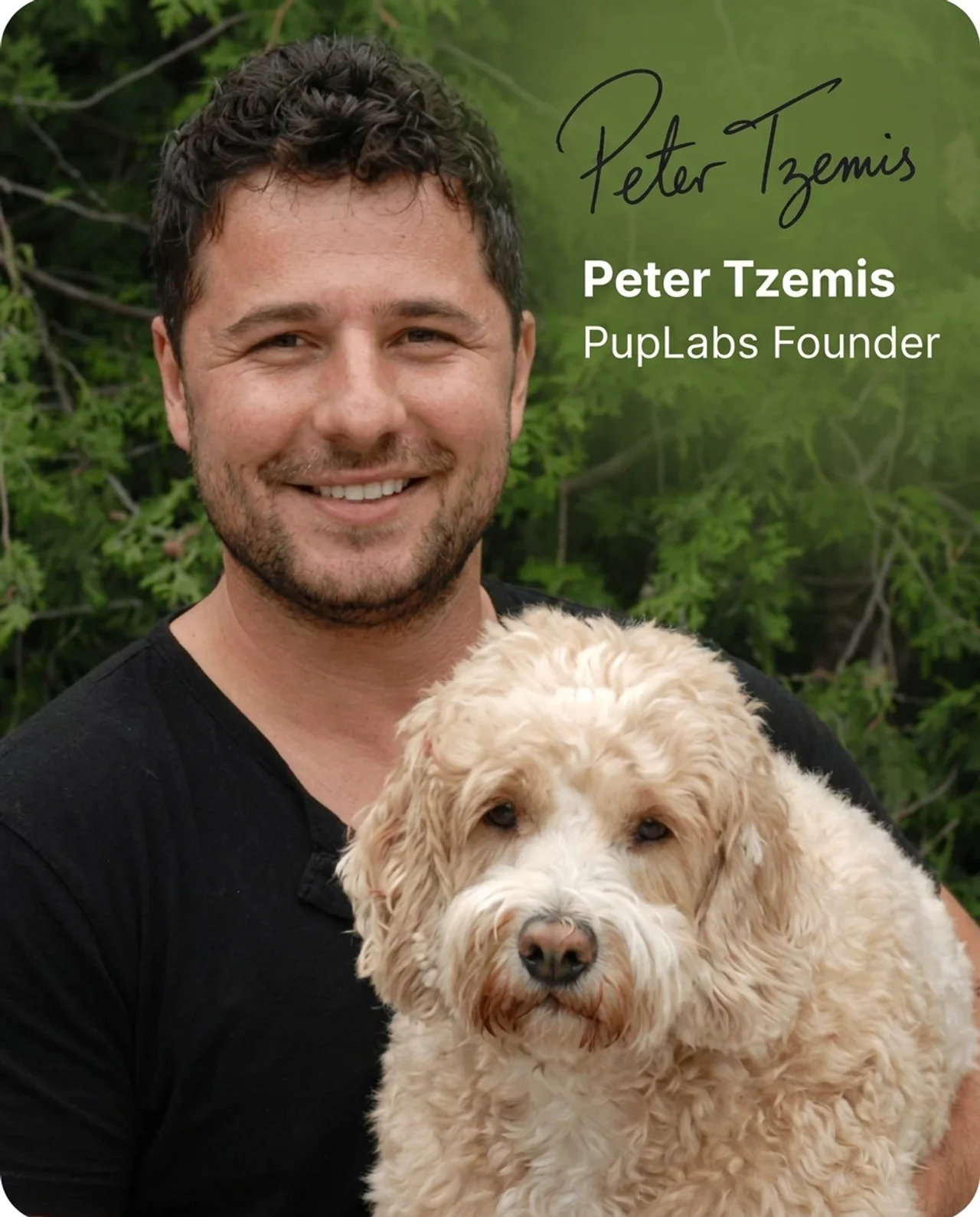 A smiling man in a black t-shirt holding a fluffy, cream-colored dog outdoors.